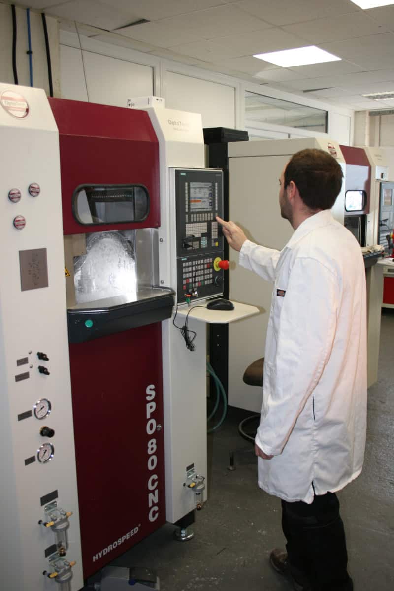 Engineer running an Optotech CNC lens polishing machine