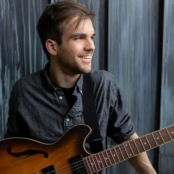 Cole Pecor, instructor at iGnitE jAzz! 2026, playing a hollow-body electric guitar.