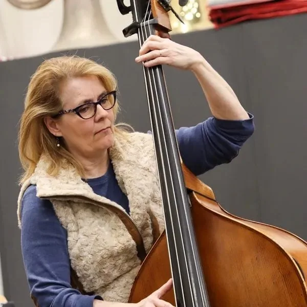 Laurie Lang, bassist and president of the Madison Jazz Society, playing an upright bass.