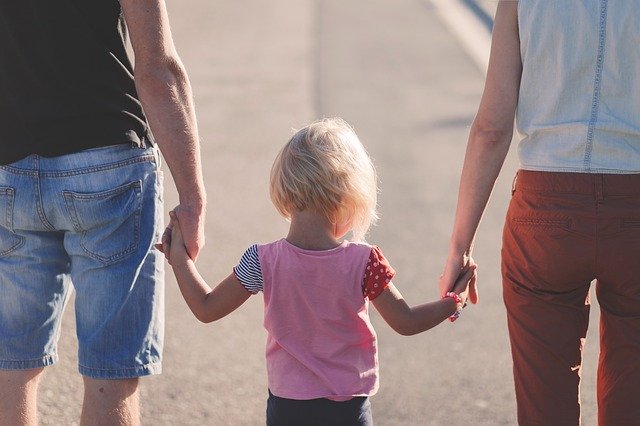 A child holding hands with both parents, illustrating unmarried parents and custody in Minnesota
