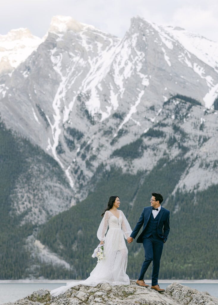 Banff elopement photographer capturing a windswept moment on a mountain overlook