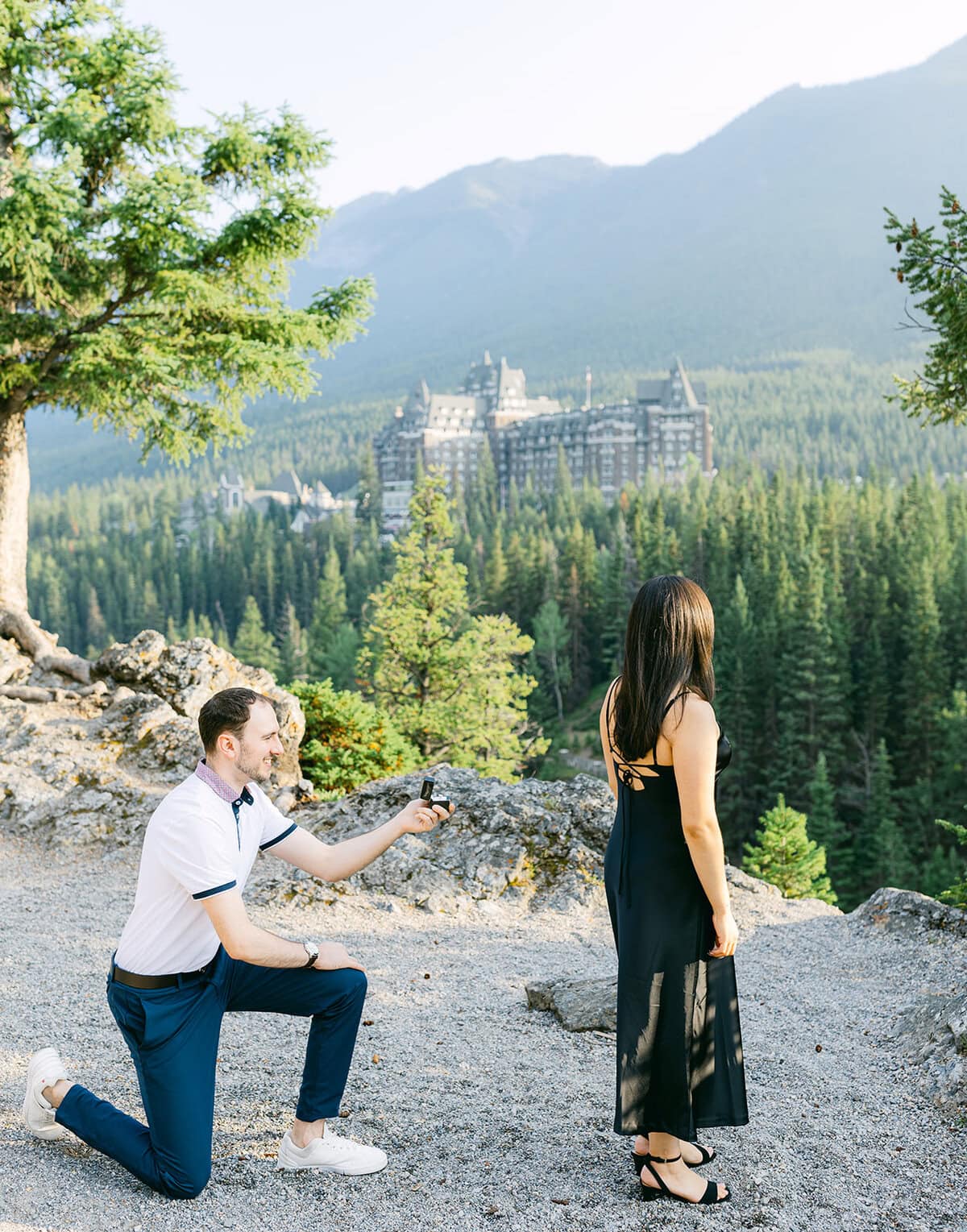 Banff proposal at Surprise Corner featuring sweeping views of the Fairmont Banff Springs Hotel during golden hour