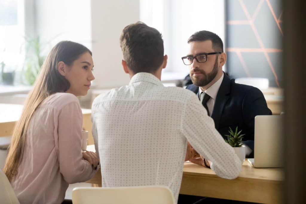 Couple meeting with an insurance attorney to discuss Florida hurricane insurance claims and important filing deadlines after storm damage.