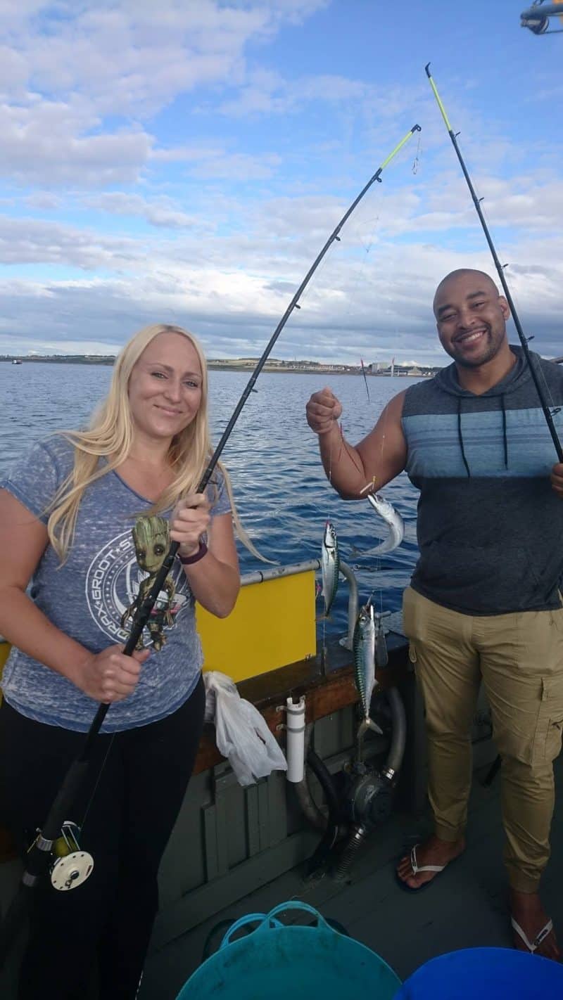 Happy anglers with caught fish on Moray Firth fishing trip in Scotland.