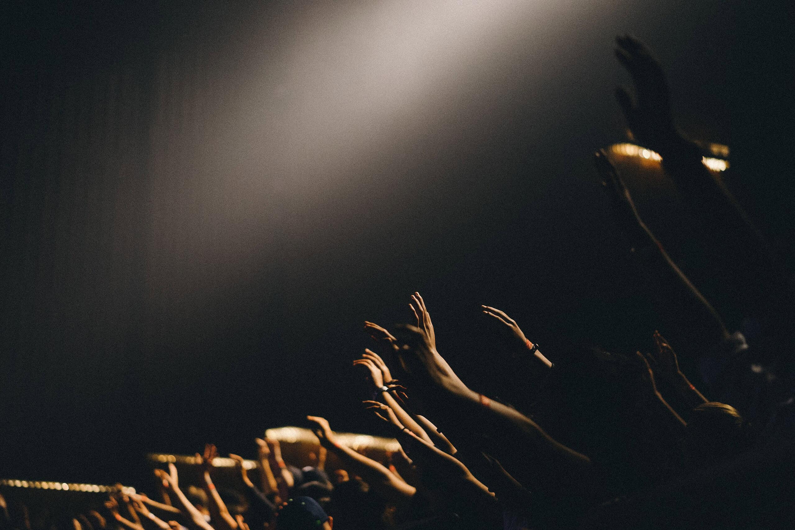 Worshippers raising hands during a live worship event at NLW International.
