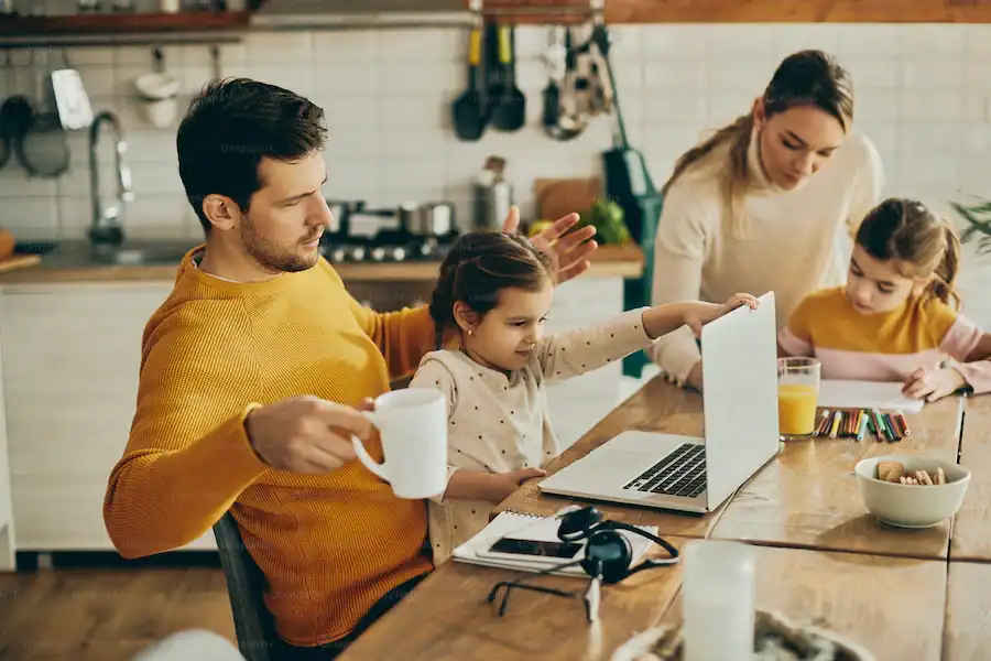 Family participating in educational activities with a laptop and art supplies.