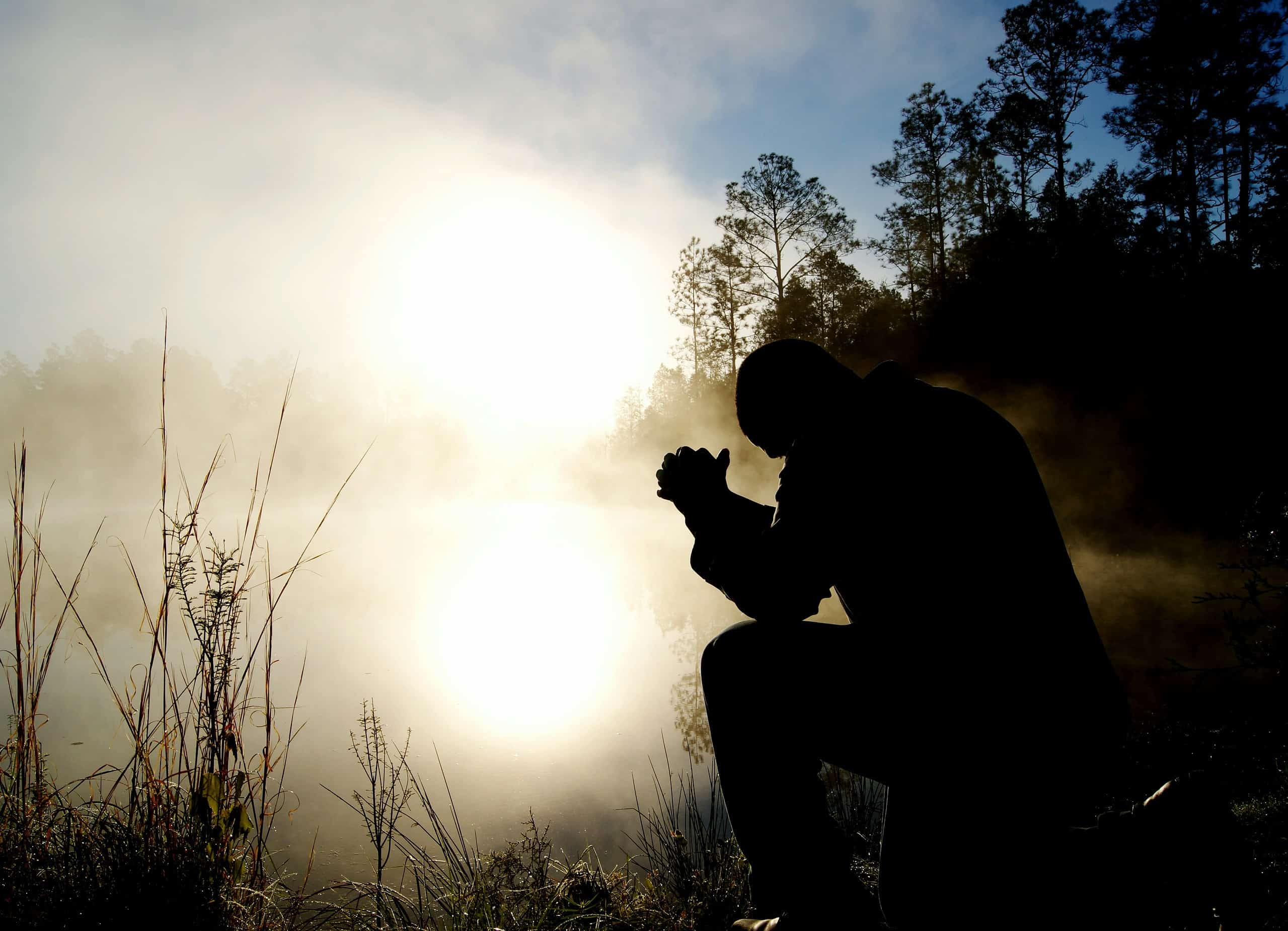 Prayer at sunrise by the lake, symbolizing devotion and spiritual worship.
