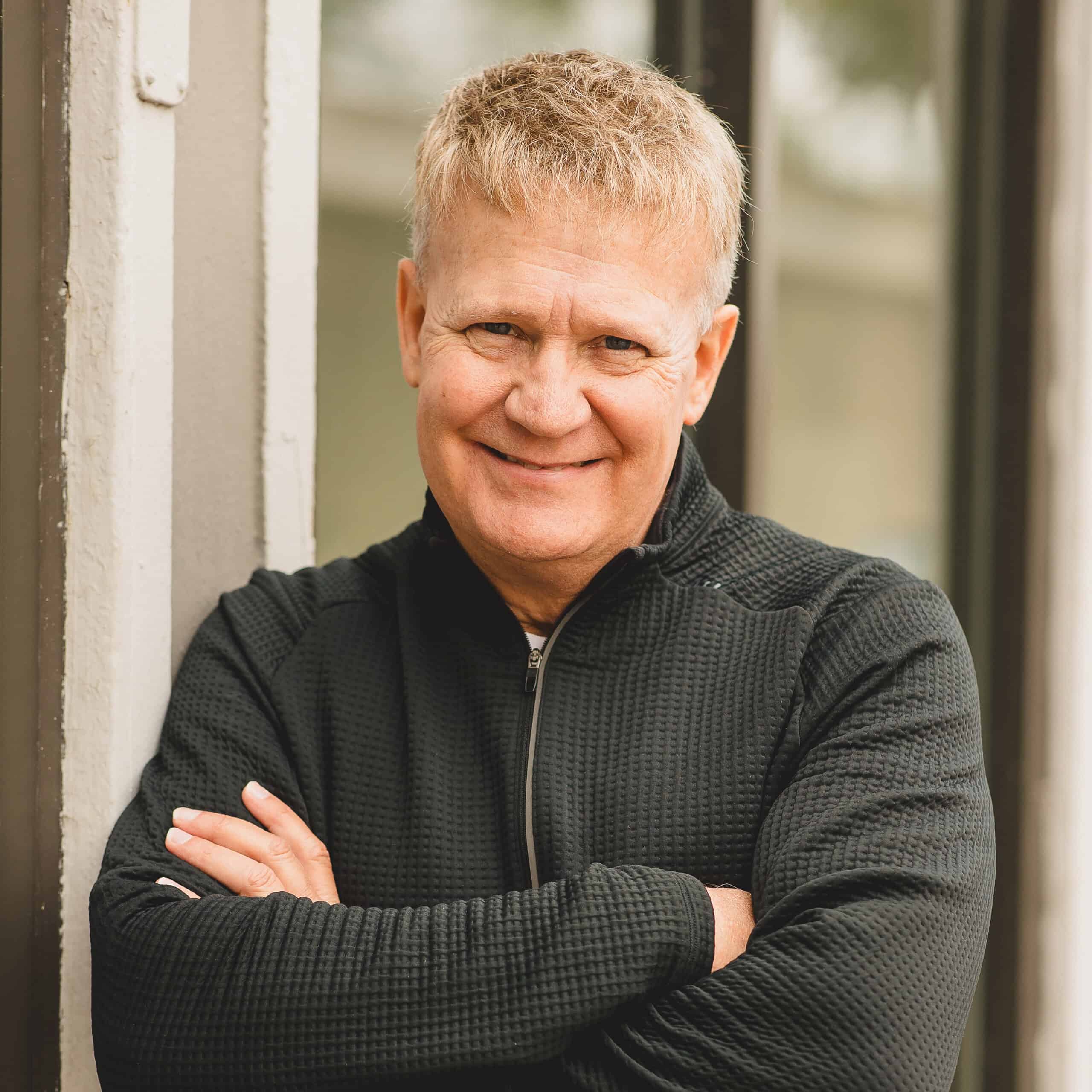 Worship leader smiling with arms crossed at NLW International event.