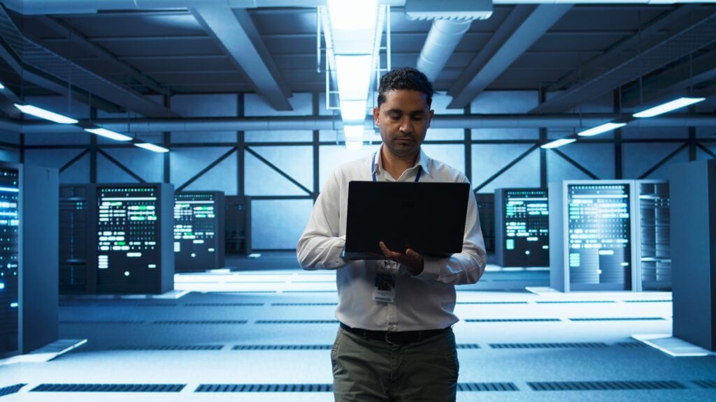 técnico de TI usando lapttop em um data center