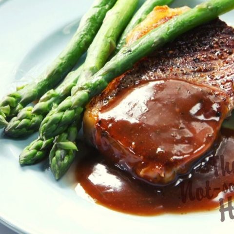 Espanole brown sauce over steak with asparagus and potatoes