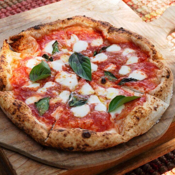 Margherita pizza made with sourdough pizza crust on a wood baking peel
