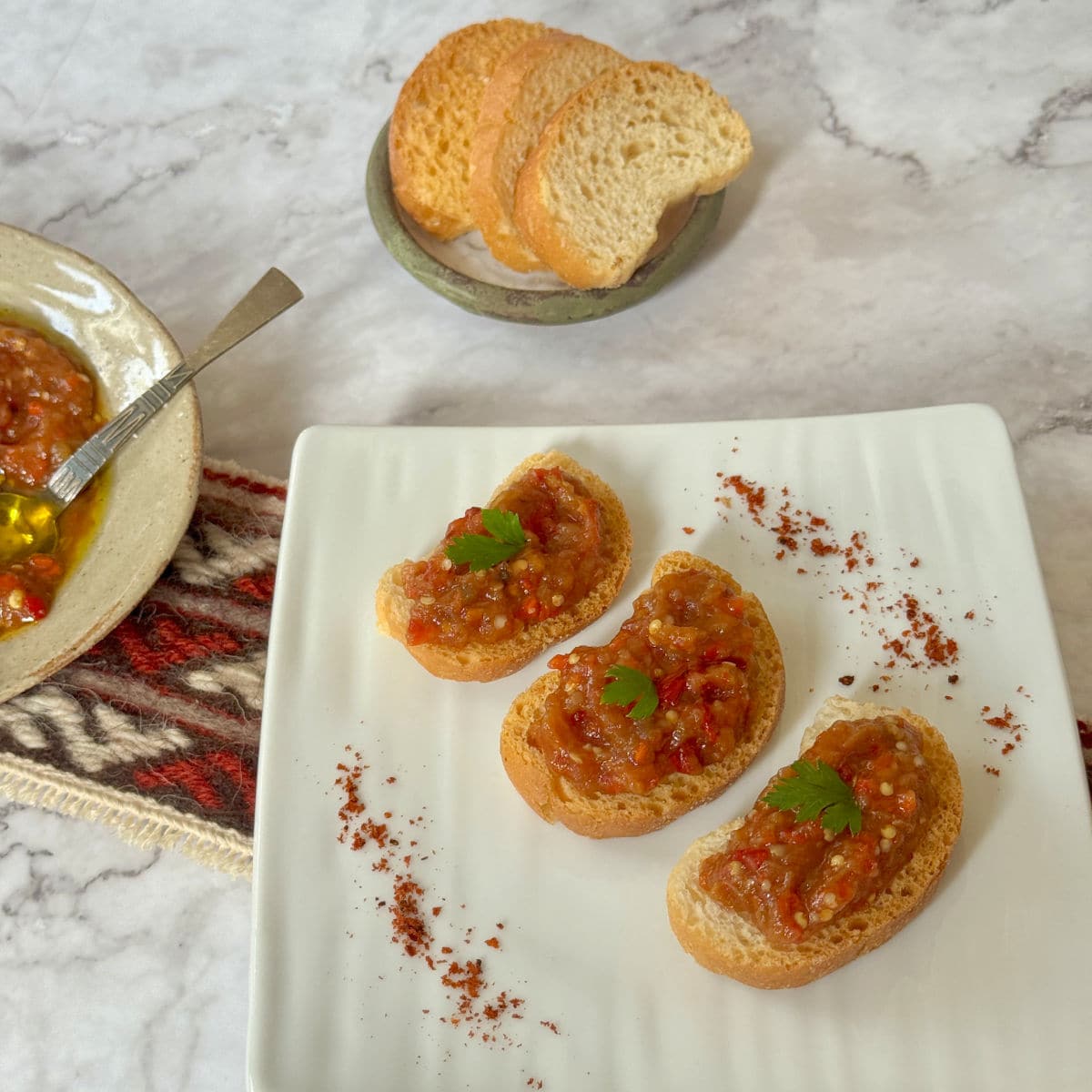 Roasted eggplant caviar spread on three toasted bread slices.