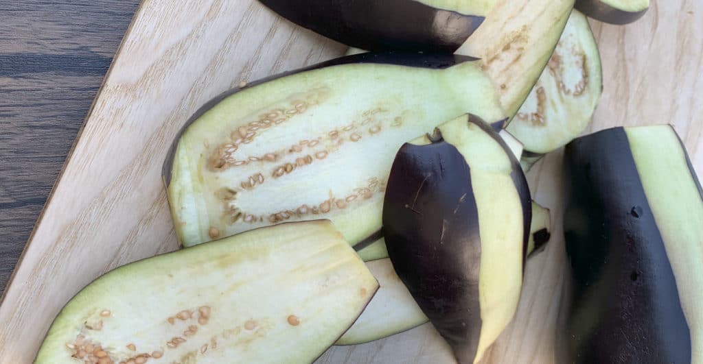 Sliced eggplants, peeled from one side.