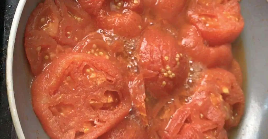 Tomatoes are stewing in a pan.