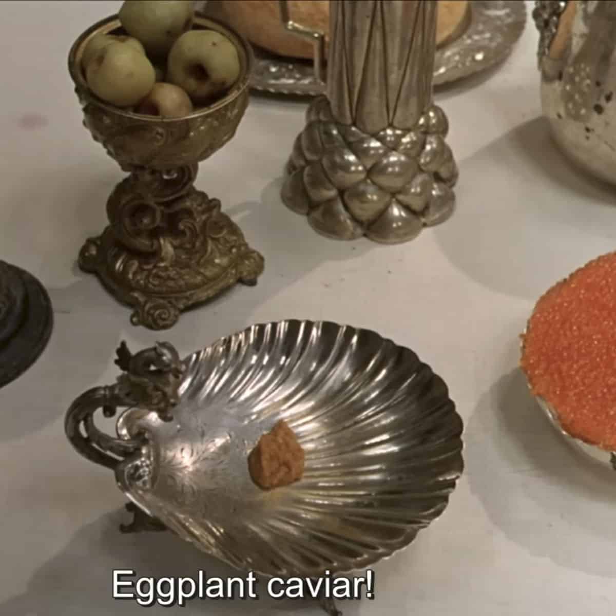 A scene from the movie, silver plate with a small dollop. of caviar on it.