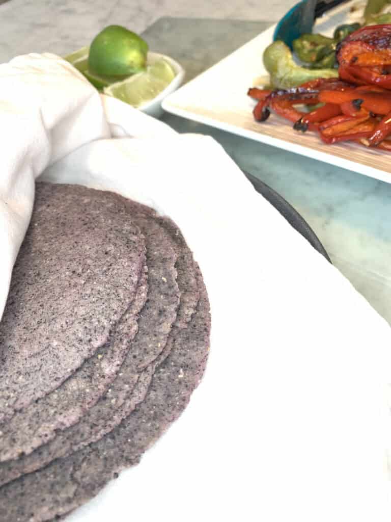 Blue corn tortillas on a plate.