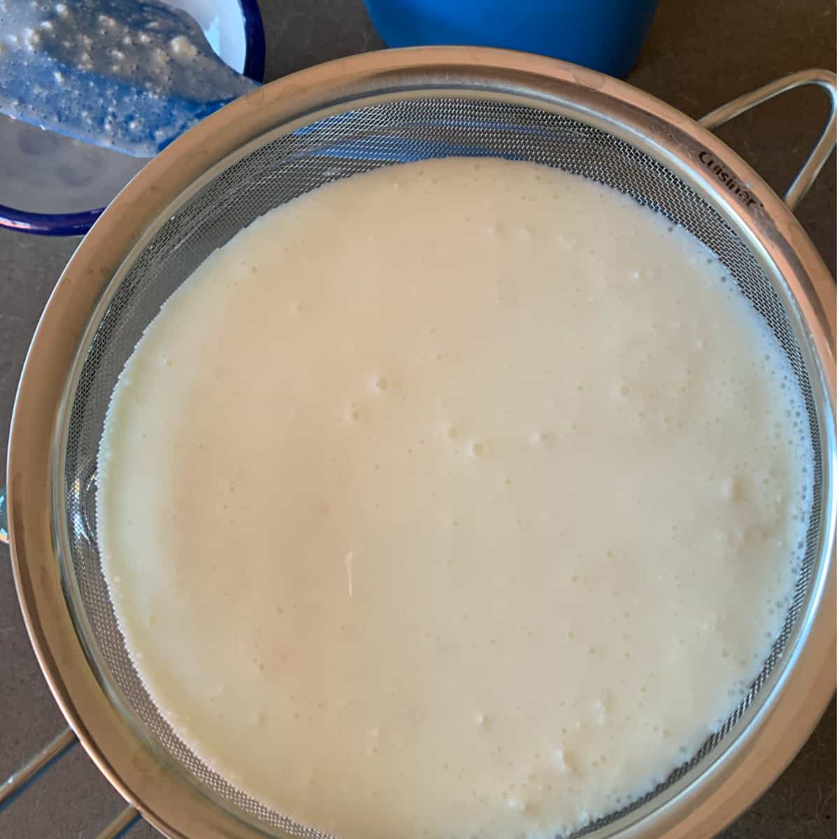 Pouring kefir through the strainer.