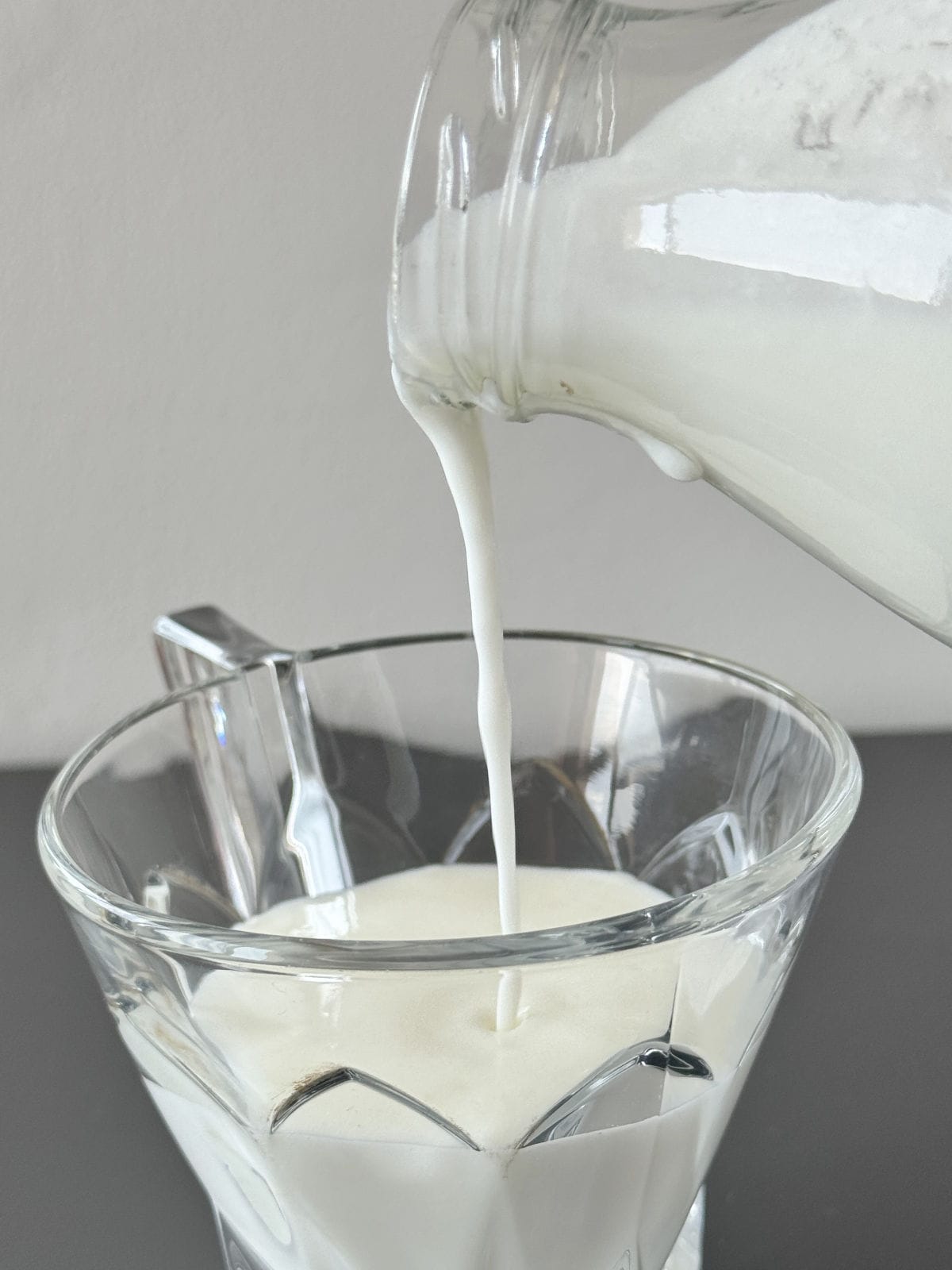 Pouring homemade kefir into a glass.