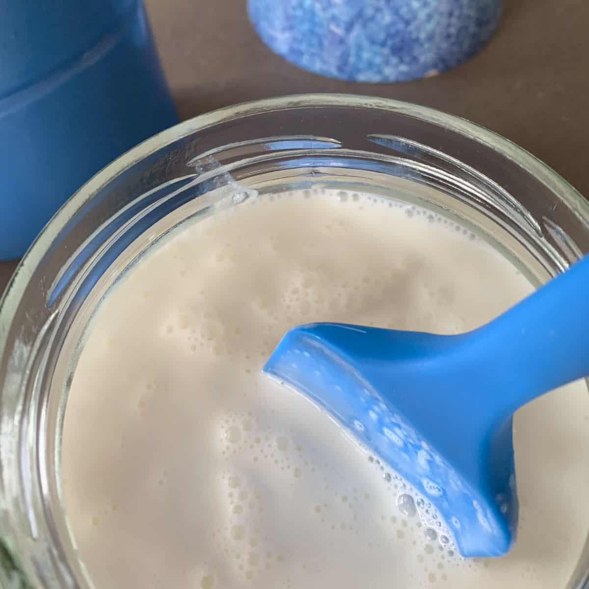 Stirring the milk with blue rubber spatula.