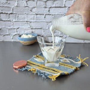 Pouring kefir into a glass.