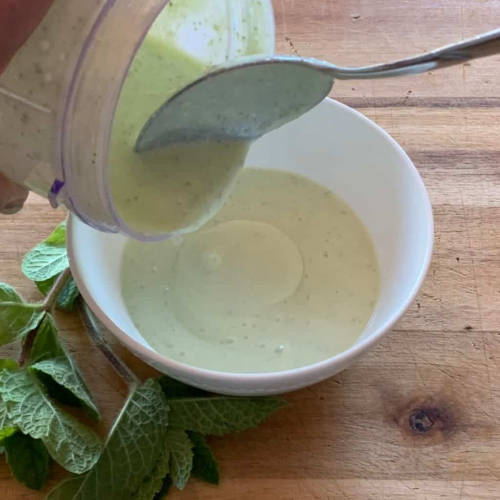 Scooping whipped feta into a bowl.