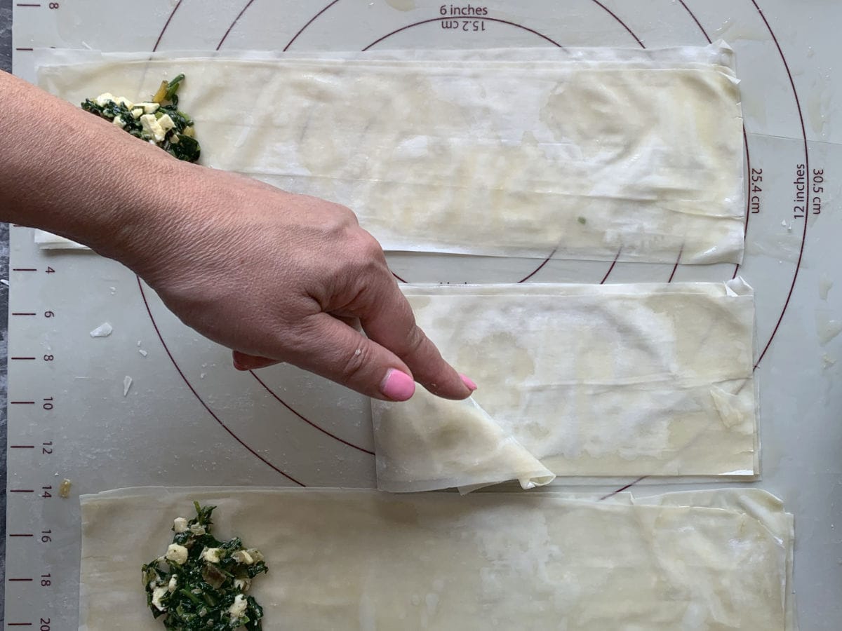 Folding phyllo dough in diagonal on the other side.