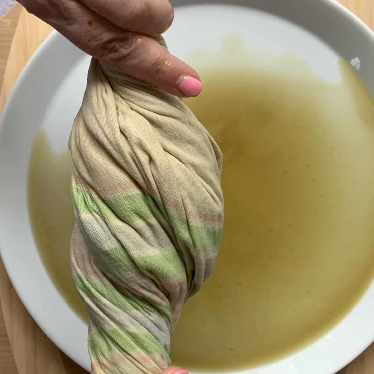 Squeezing the liquid from the cooked spinach.