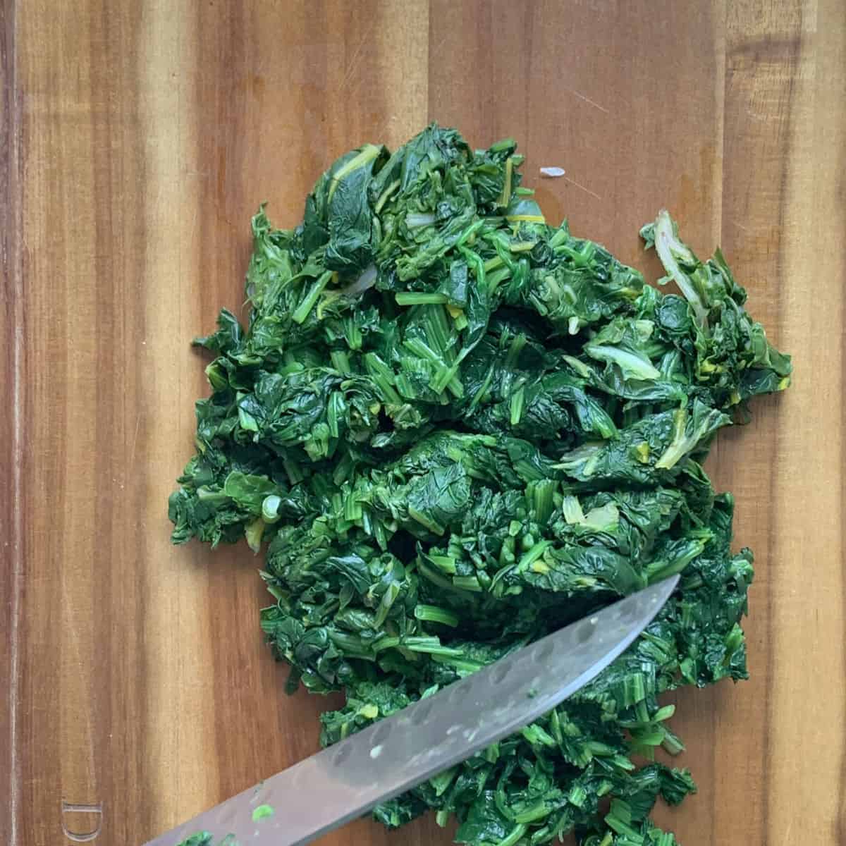 Chopping the cooked spinach.