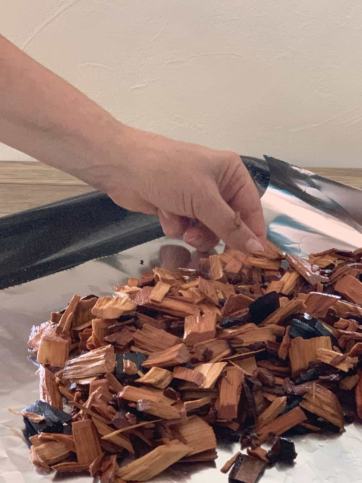 Distributing the wood chips in a pan.
