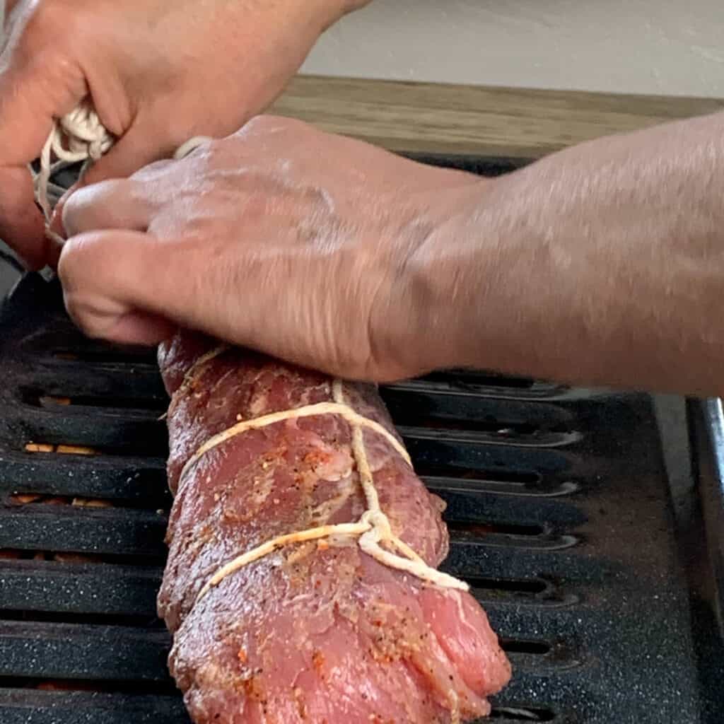 Placing the pork on a broiler pan.