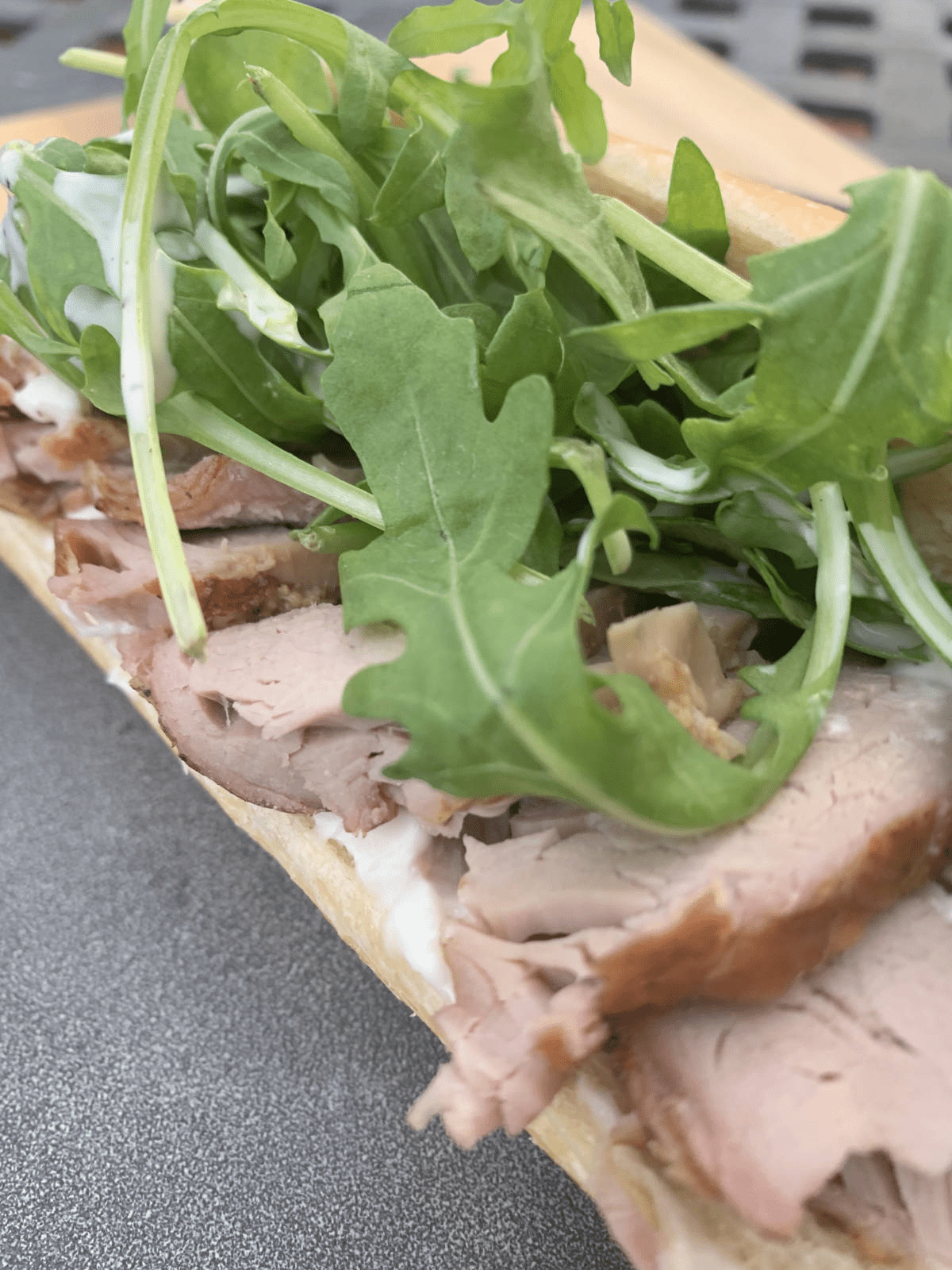 Smoked tenderloin sandwich with mayo and arugula.