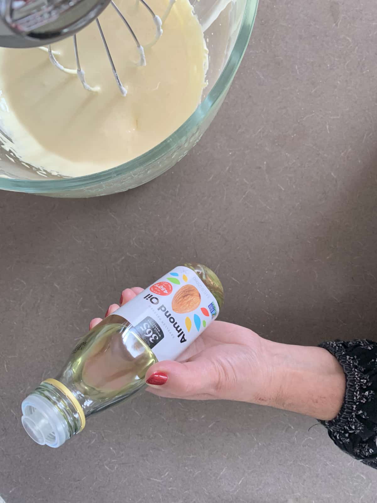 Adding almond oil to whipped yolks.