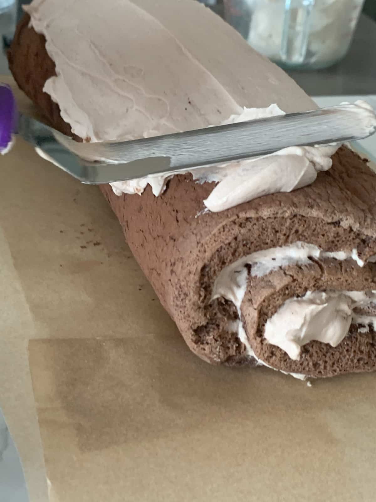 Spreading tiramisu frosting on the cake,