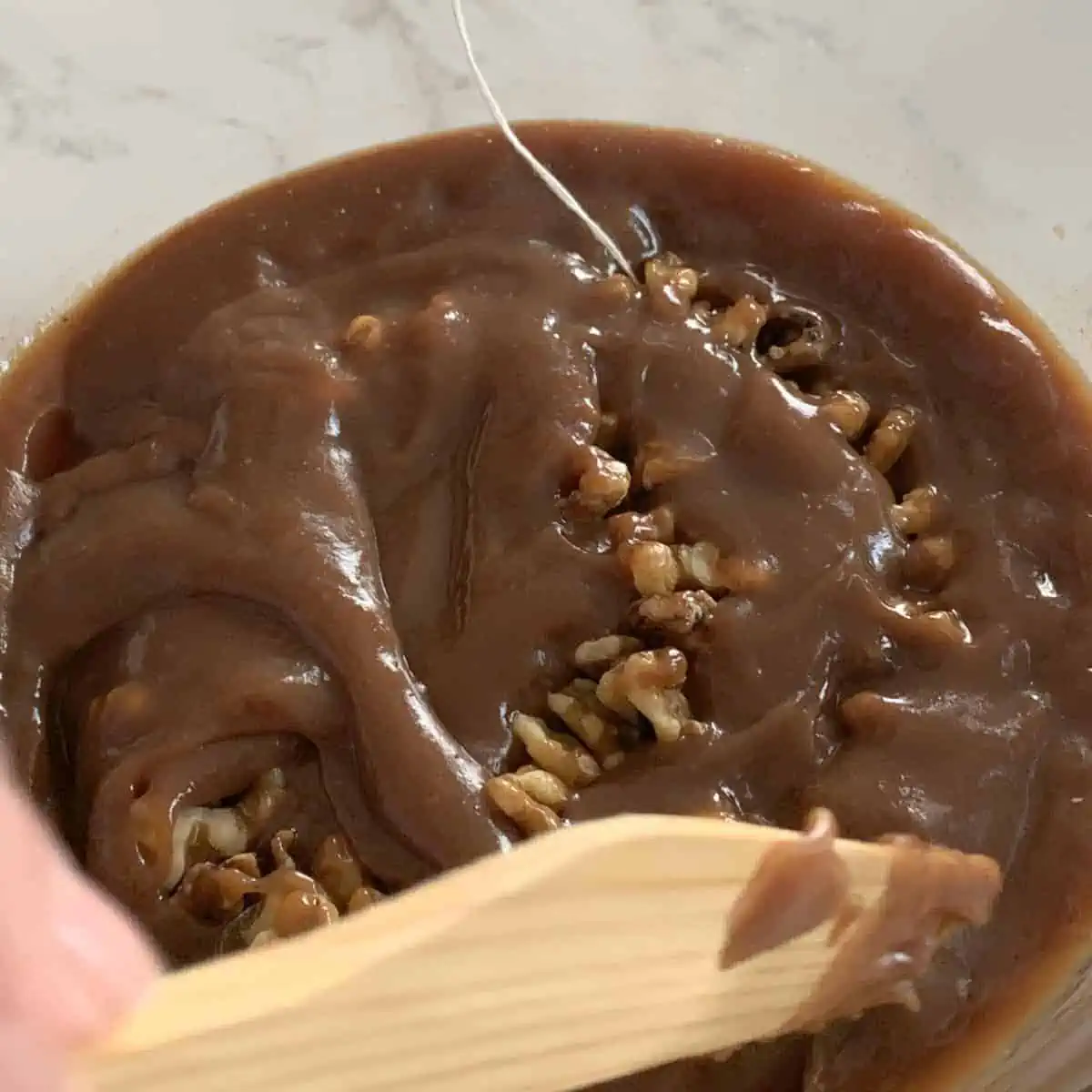 Submerging walnut string in shpot.