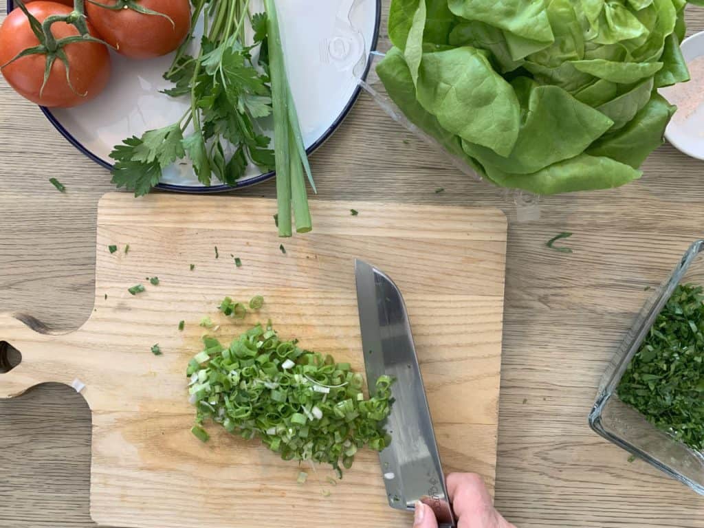 Chopping scallions for garnish.