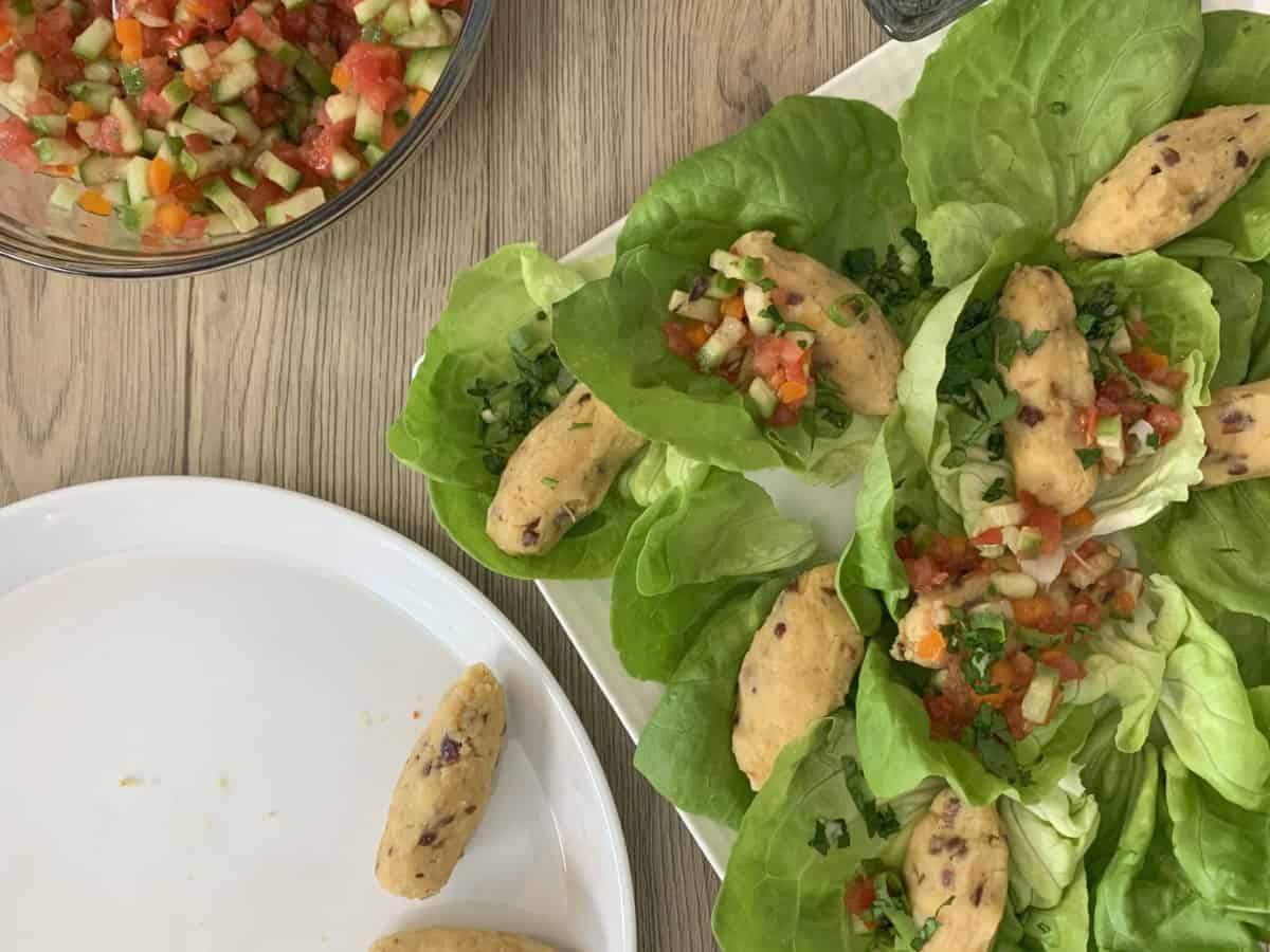 Nestling lentil rolls in lettuce leaves and garnishing.