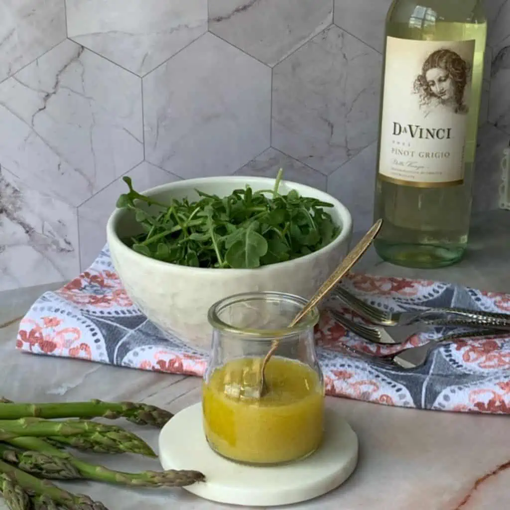 White Balsamic Vinaigrette in a foreground and salad in a background.