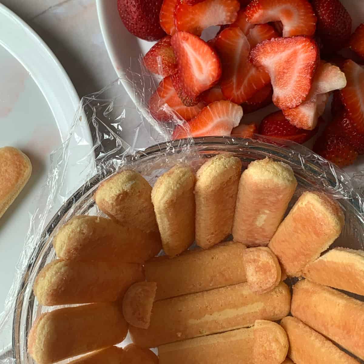 Ladyfingers arranged in the glass bowl.