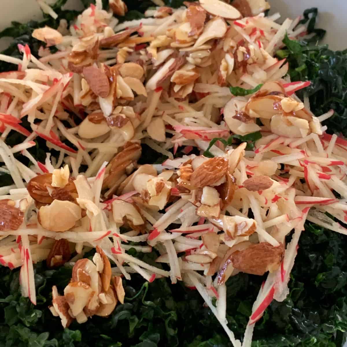 Kale topped with shredded apples and almond praline.