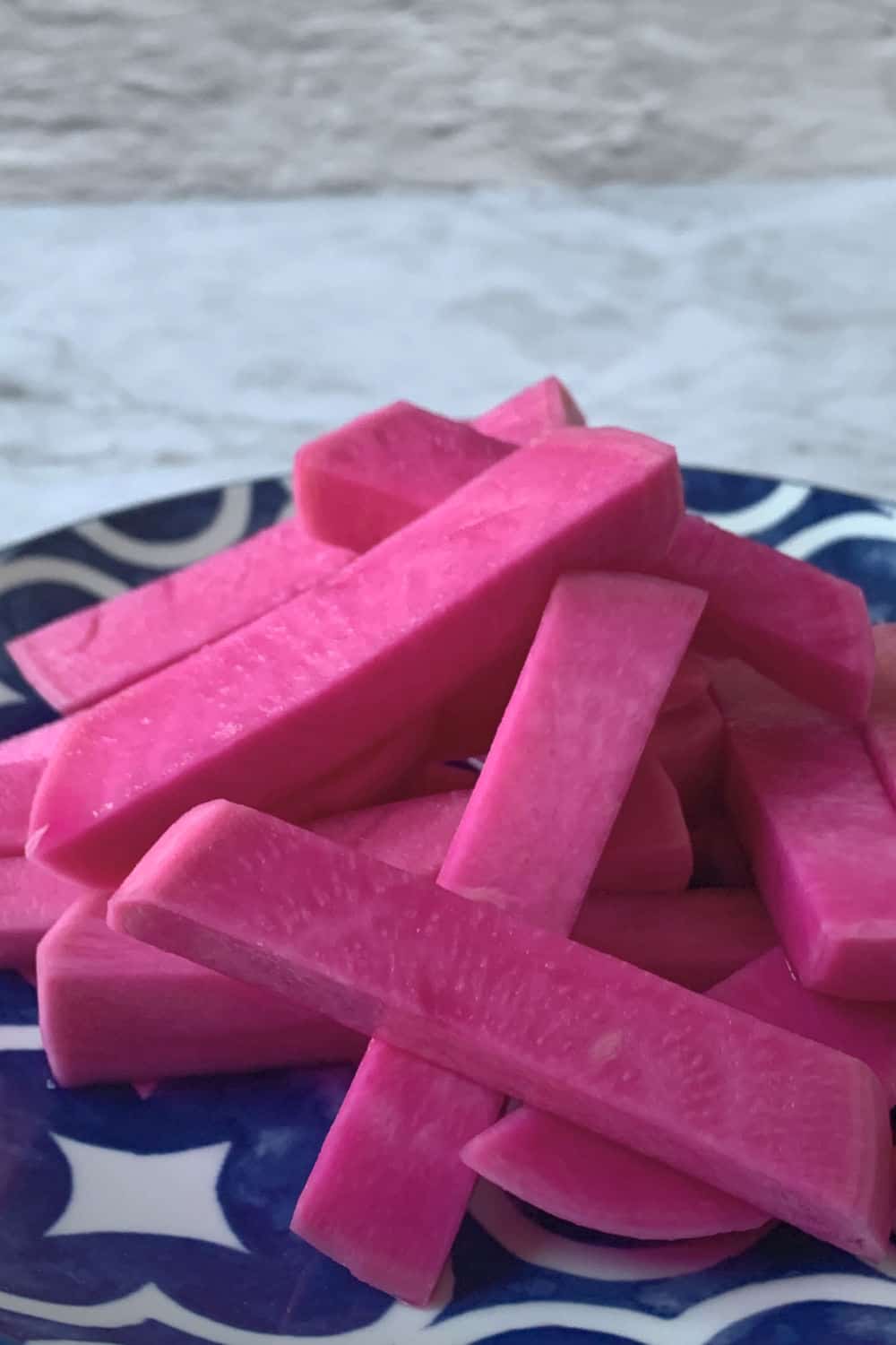 Pink turnip batons on a blue plate.