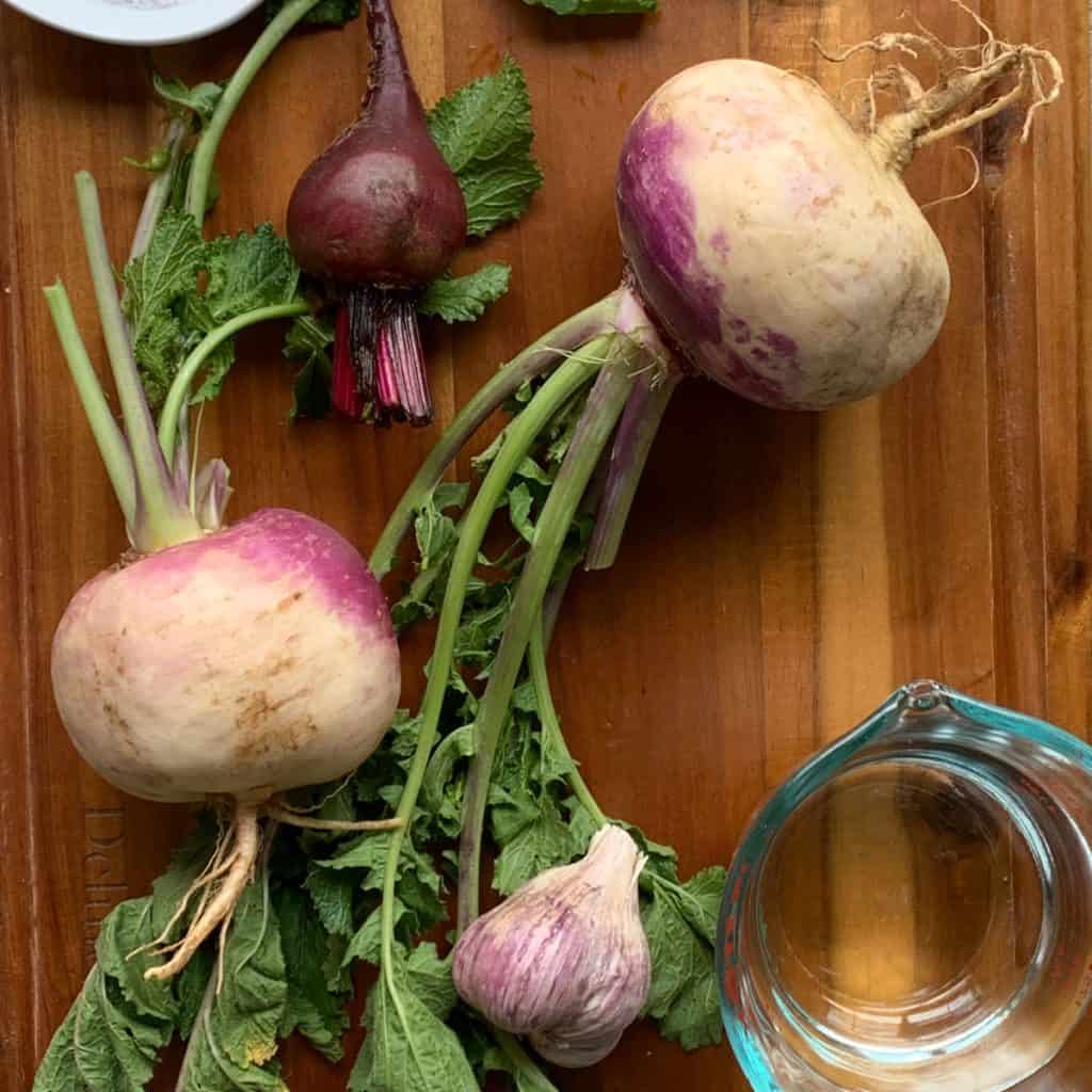 Turnip, beets, salt and vinegar on a cutting board.