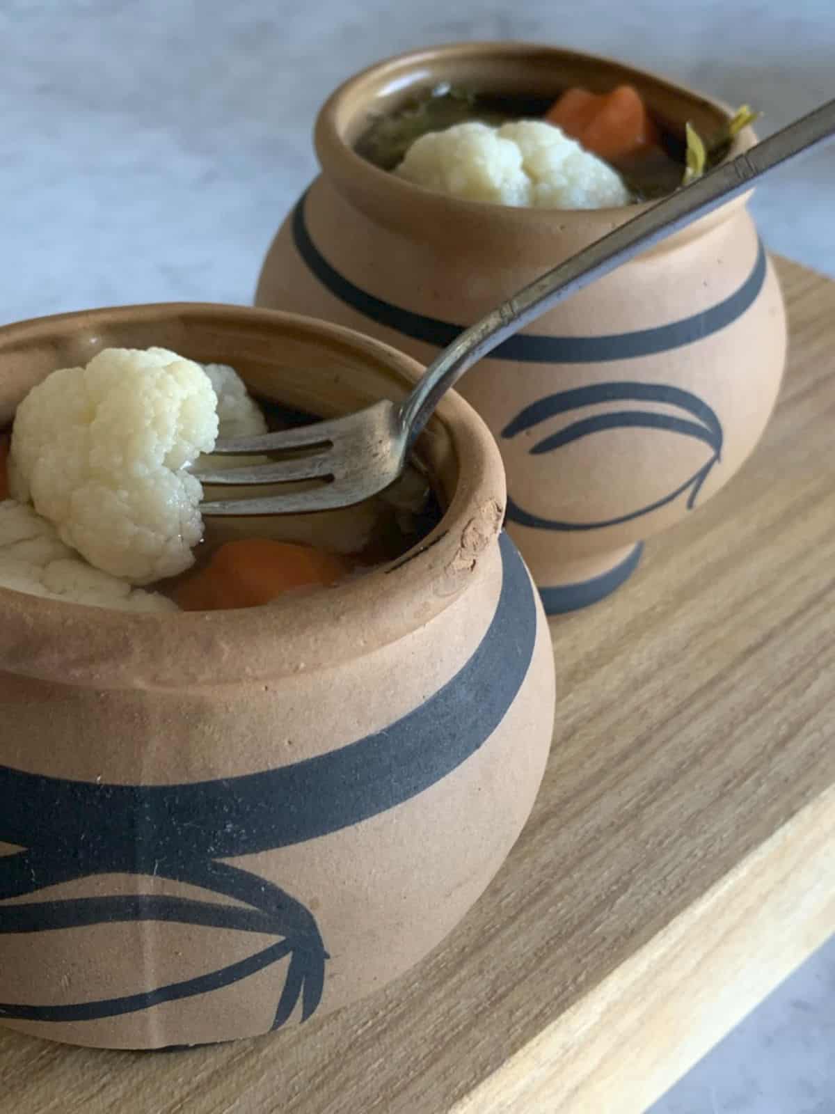 Pickled vegetables in a small clay pots.