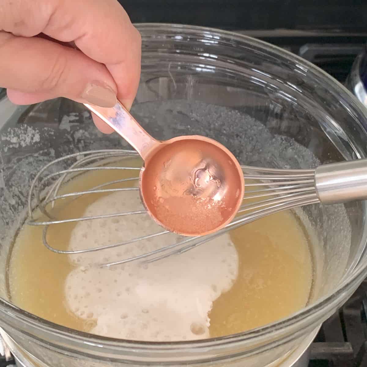 Adding baking soda and vinegar to a batter.
