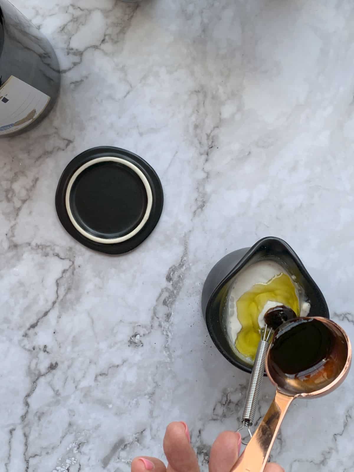 Adding honey to sour cream dressing.