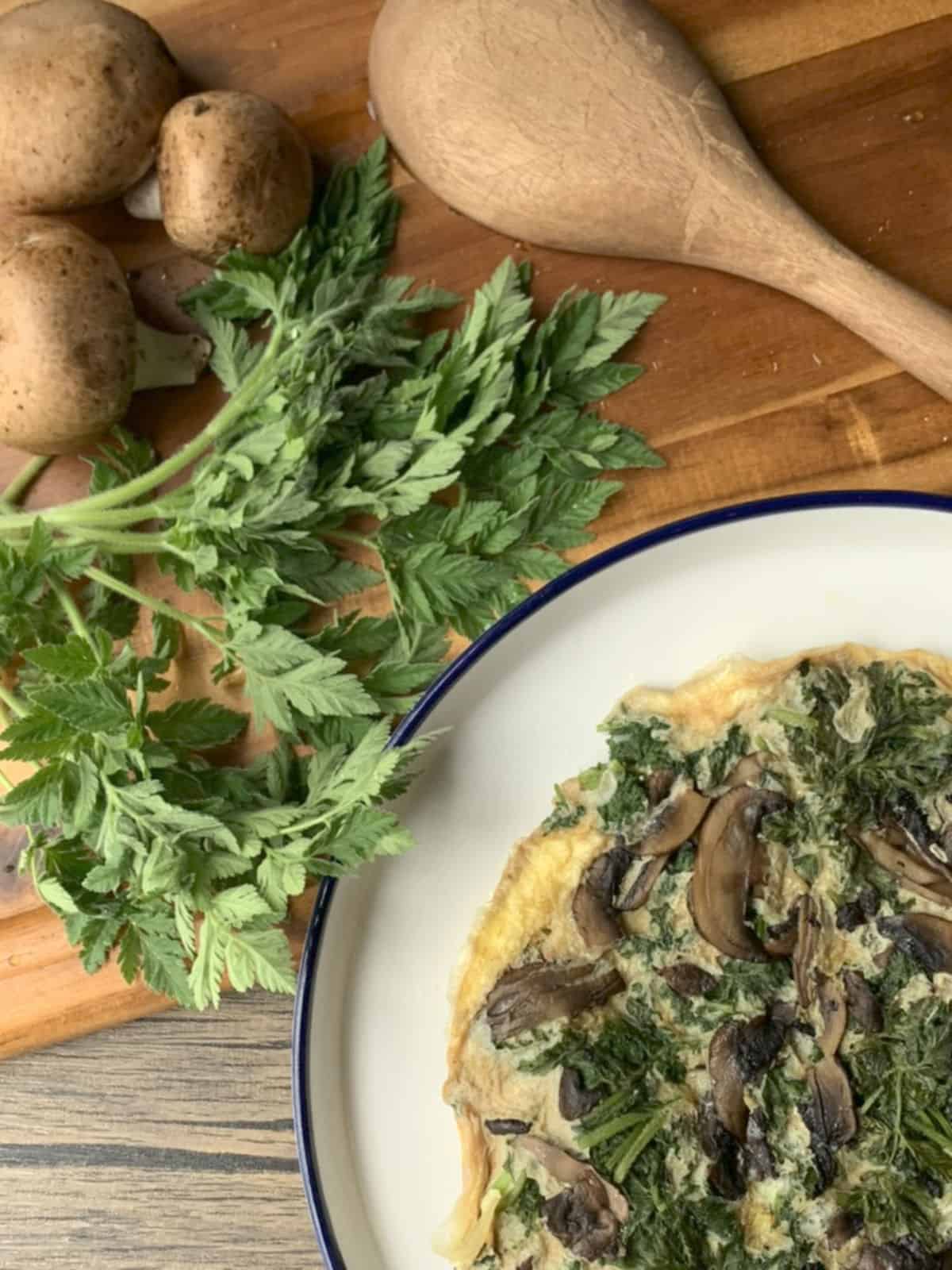 a plate of food next to mushrooms and a spoon.
