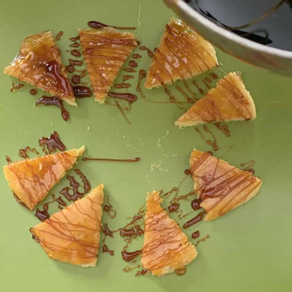 Drizzling caramel on a cake layer wedges.