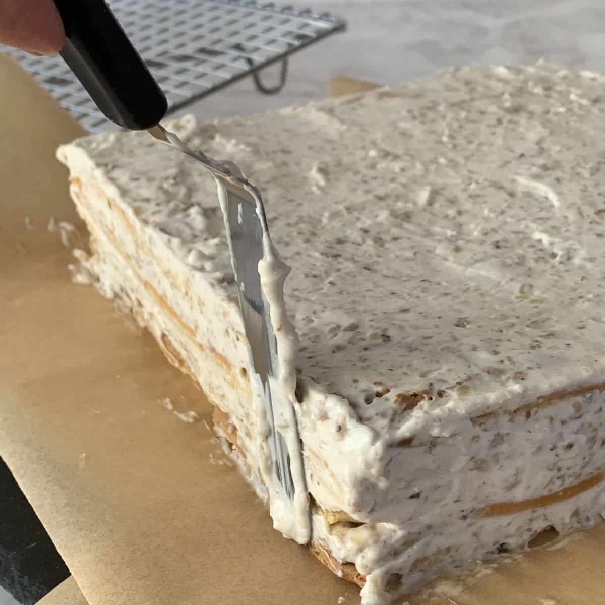 Applying frosting all around the cake.