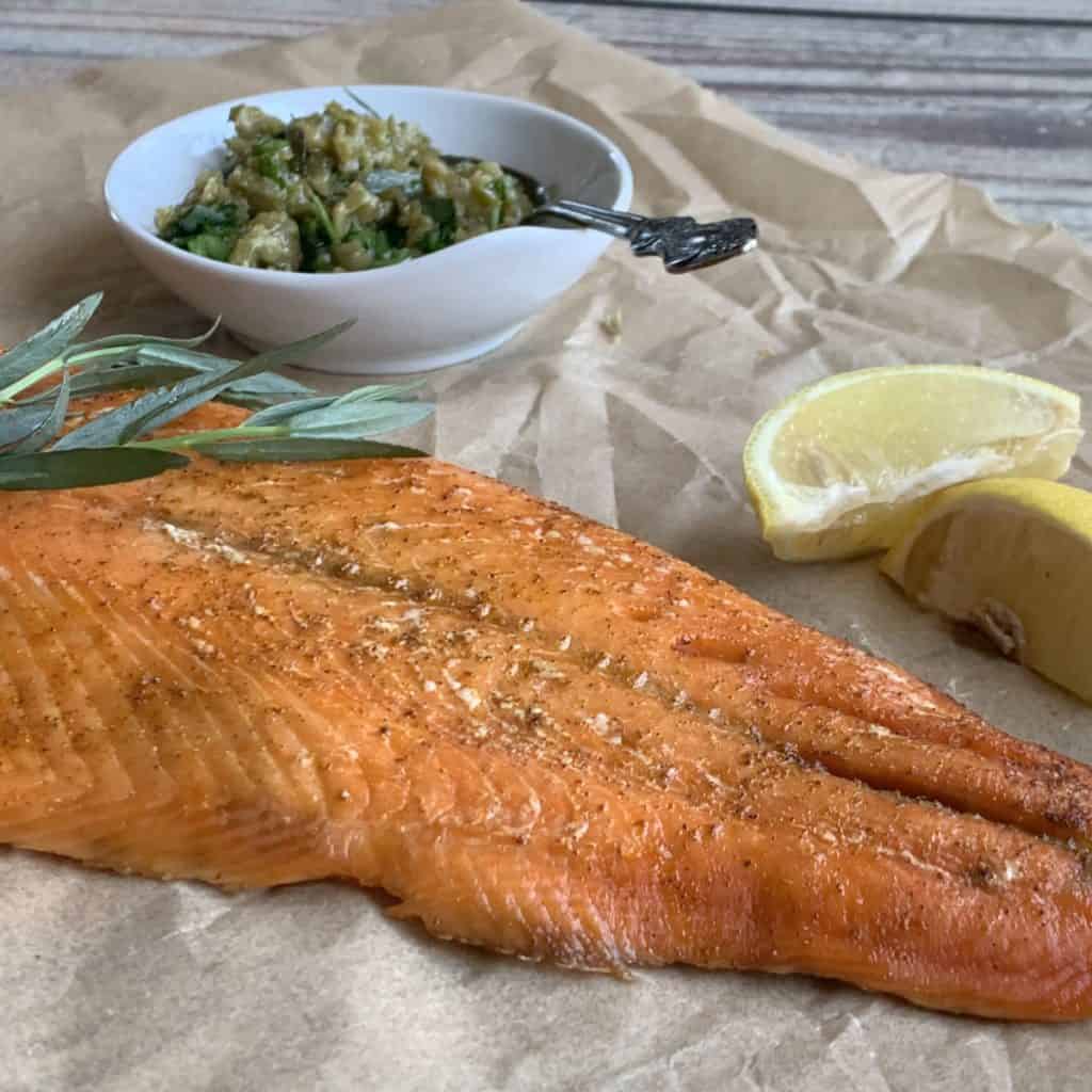 Smoked salmon with olive caper tapenade and lemon wedges.