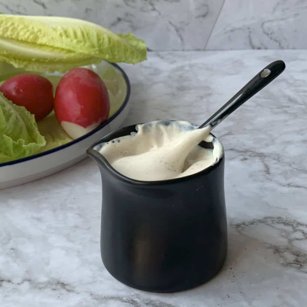 Sour cream dressing in a black sauce jar.