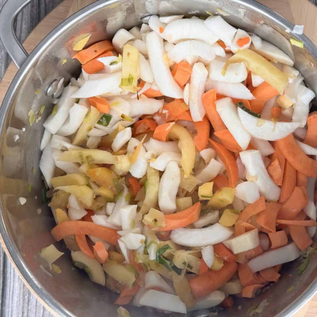 Sautéing the chopped vegetables in a pot.